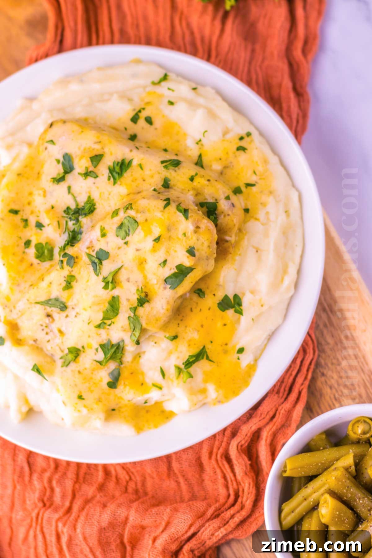 A plate of slow cooker ranch pork chops with creamy gravy, a perfect easy dinner recipe.