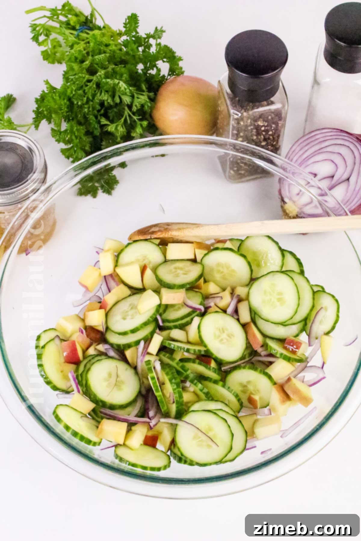 Tossing the ingredients of a fresh Apple Cucumber Salad.