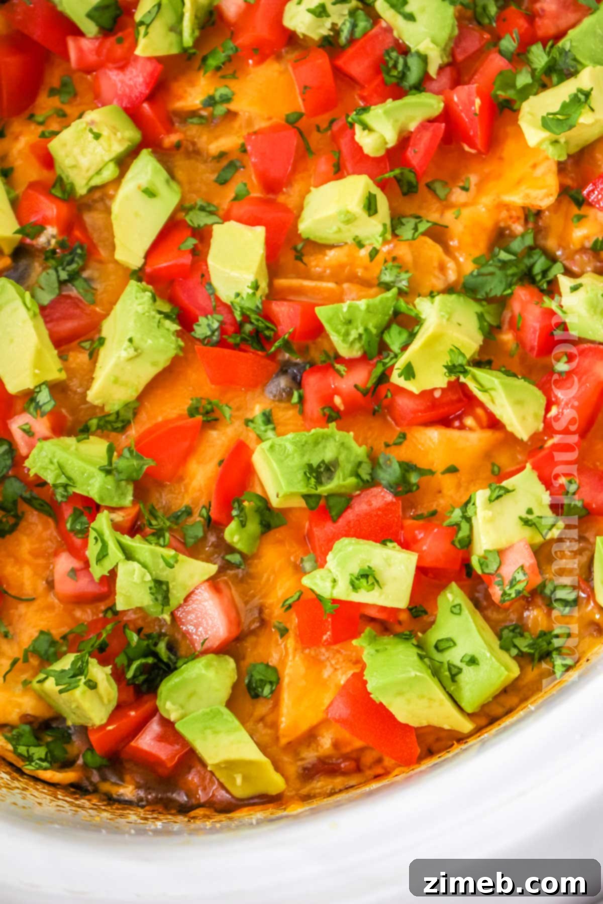 Easy Slow Cooker Mexican Casserole 3 Overhead shot of a Crockpot Mexican Casserole with cheese and fresh toppings, serving suggestion.