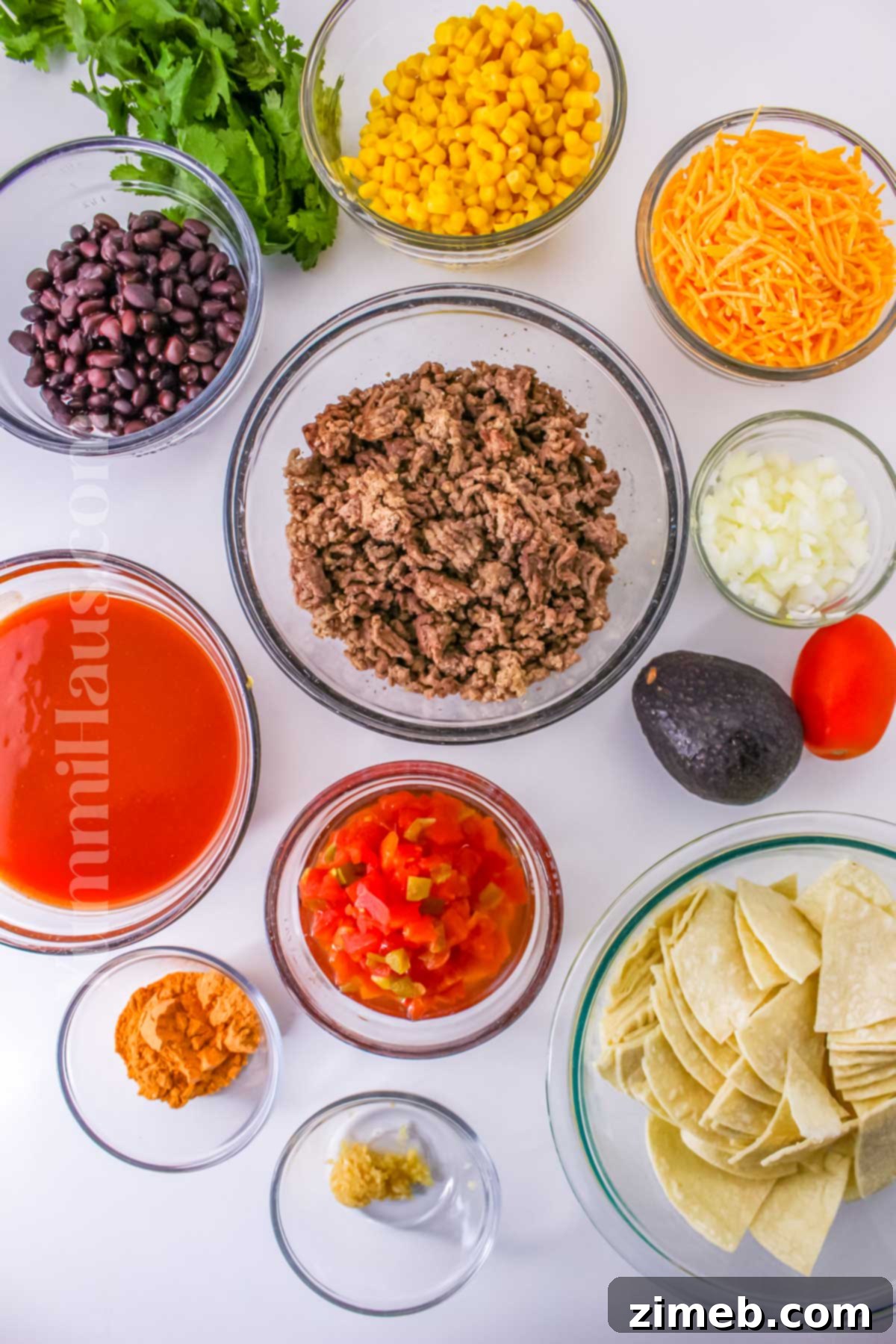 Easy Slow Cooker Mexican Casserole 4 Various ingredients for Crockpot Mexican Casserole laid out, including ground beef, corn, beans, cheese, and sauce.