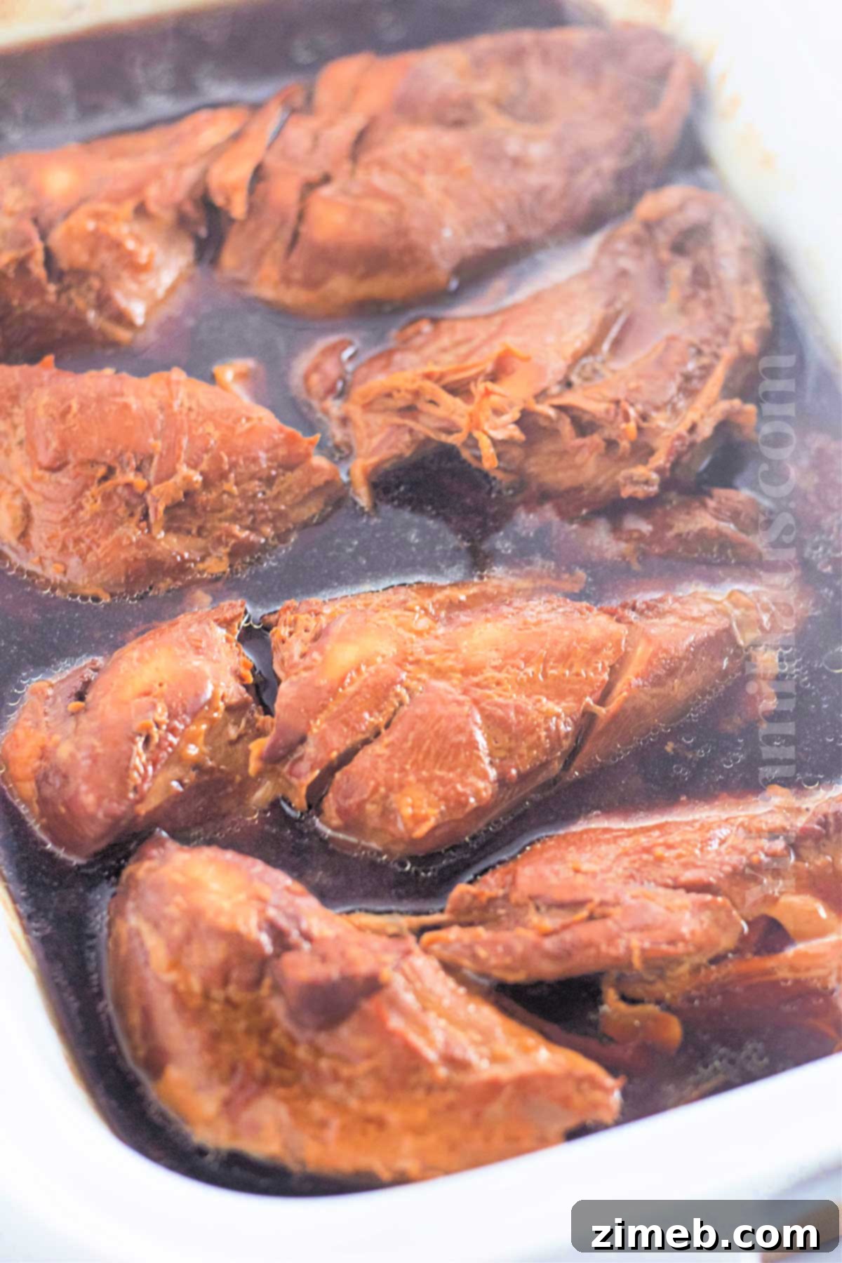 Caramelized Honey Garlic Chicken 7 Cooked Slow Cooker Garlic Honey Chicken, shredded and coated in its sweet and savory sauce, ready to be served.