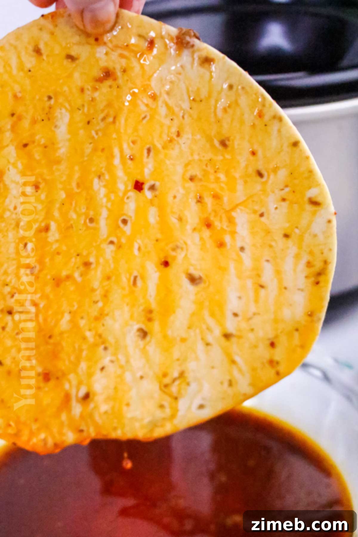 Easy Slow Cooker Birria Tacos 8 dipping the tortillas