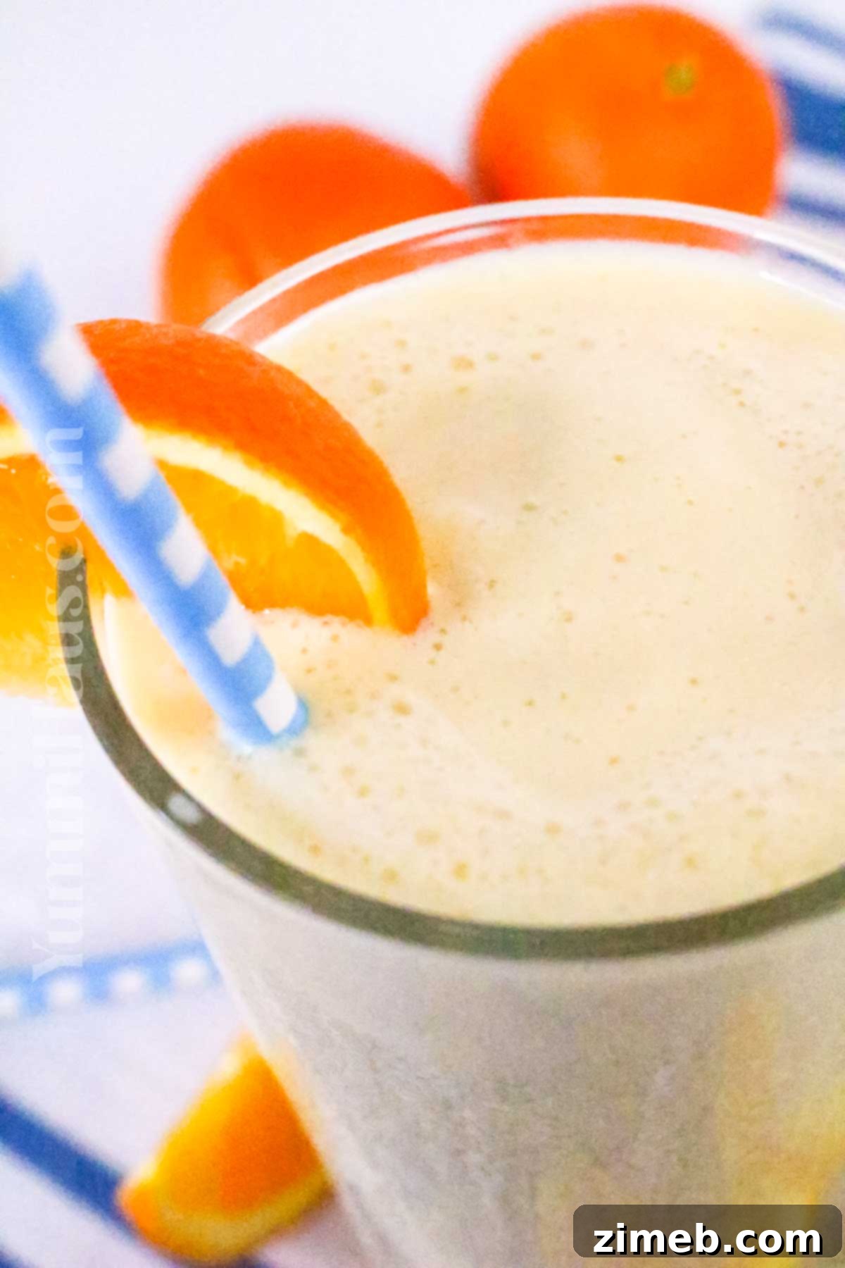 Classic Orange Julius drink in a tall glass, garnished with an orange slice