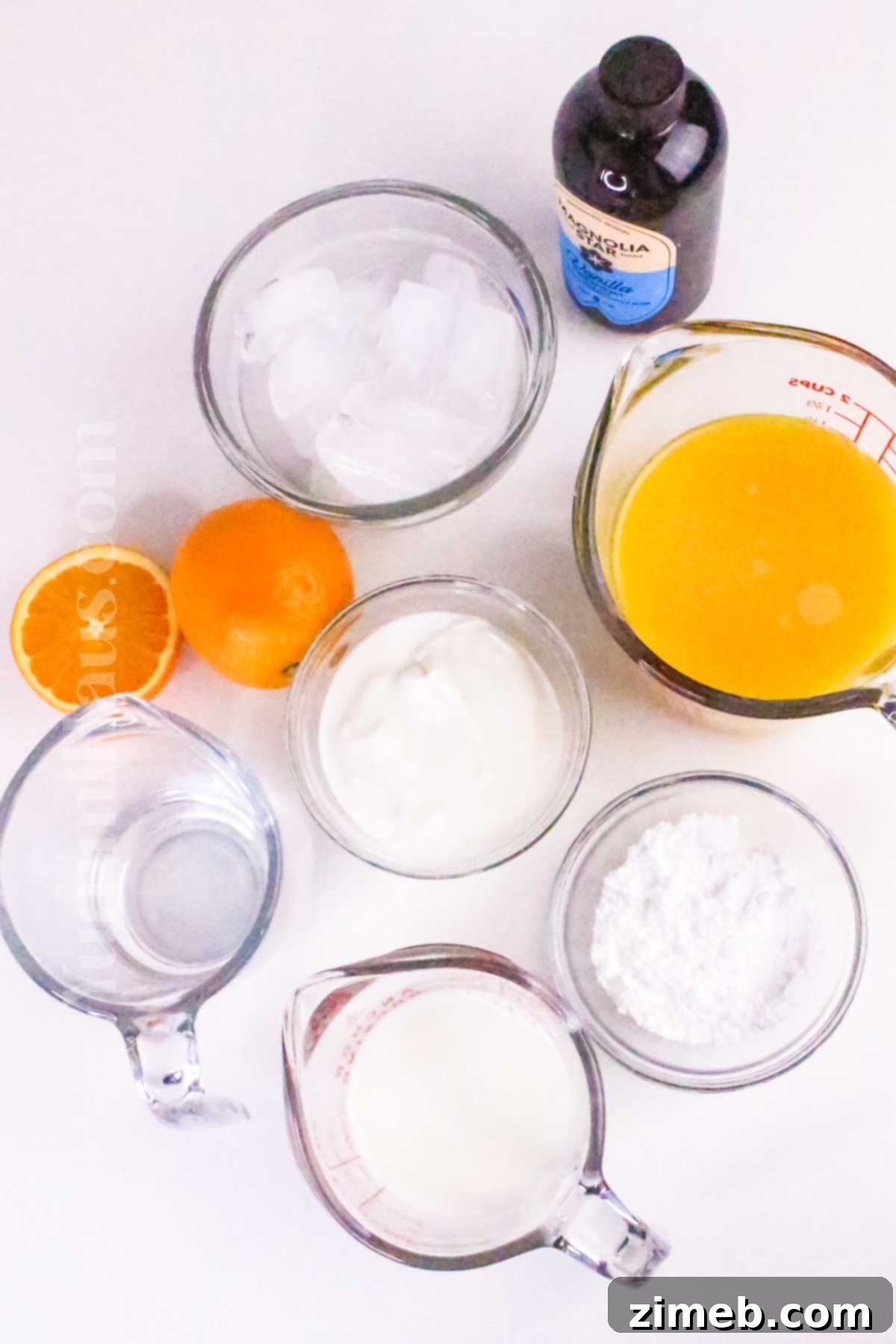 Fresh ingredients for Orange Julius: orange juice, milk, sugar, vanilla, ice, and optional Greek yogurt.