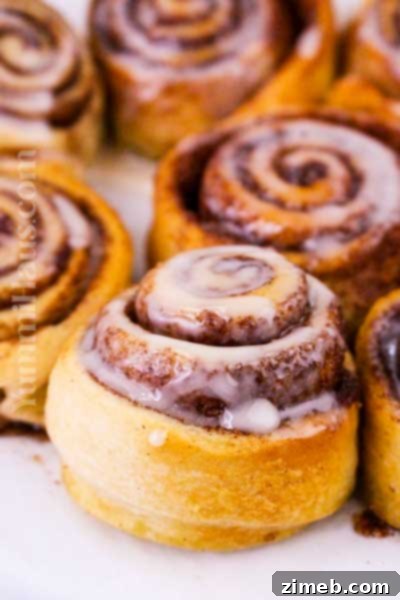 Warm, gooey Cinnamon Rolls with a golden, crispy finish from an Air Fryer, drizzled with sweet icing.