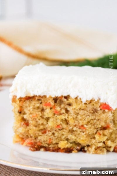 A moist and flavorful Carrot Cake with Pineapple, topped with a creamy, decadent frosting, garnished with walnuts.