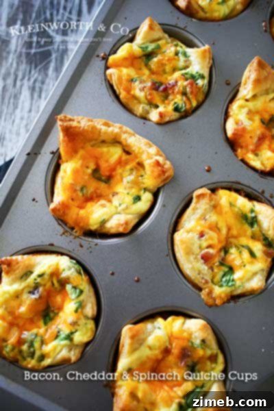 Bite-sized Bacon Cheddar & Spinach Quiche Cups, baked in flaky puff pastry, filled with a savory blend of bacon, cheddar, and spinach.
