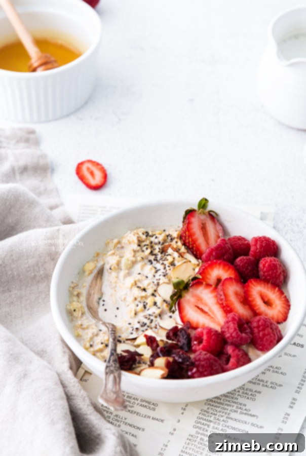 A jar of healthy Easy Overnight Oats, layered with fresh berries and granola, a perfect make-ahead breakfast.