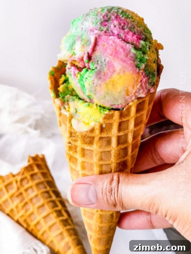 Homemade Rainbow Sherbet with vibrant swirls of orange, lime, and pink lemonade flavors in a glass bowl, ready to be served.
