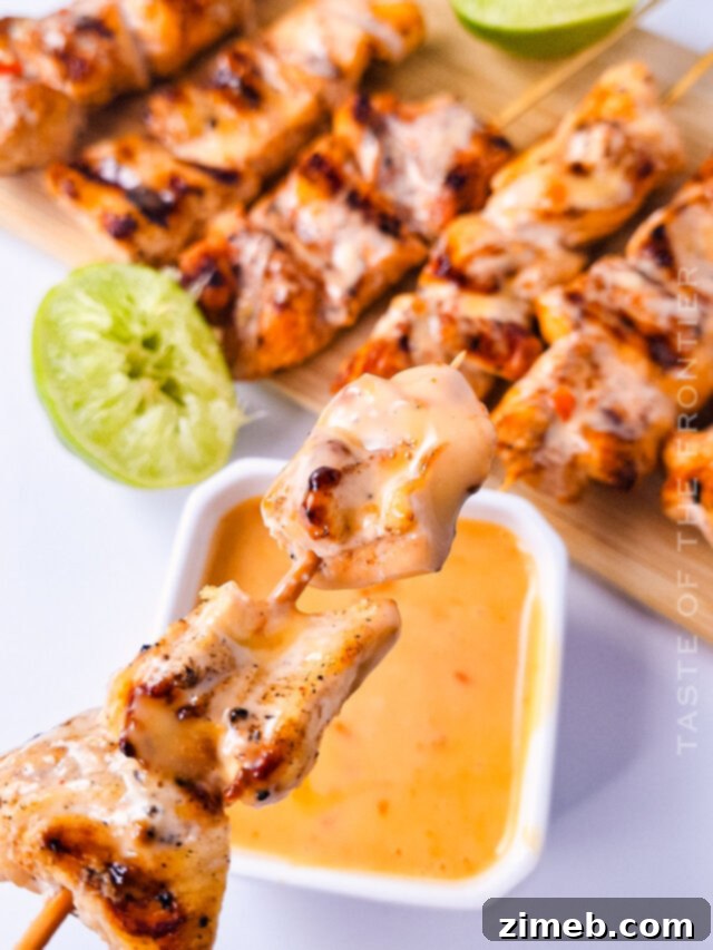 Juicy grilled chicken skewers coated in a creamy, spicy-sweet bang bang sauce, garnished with sesame seeds and fresh herbs.