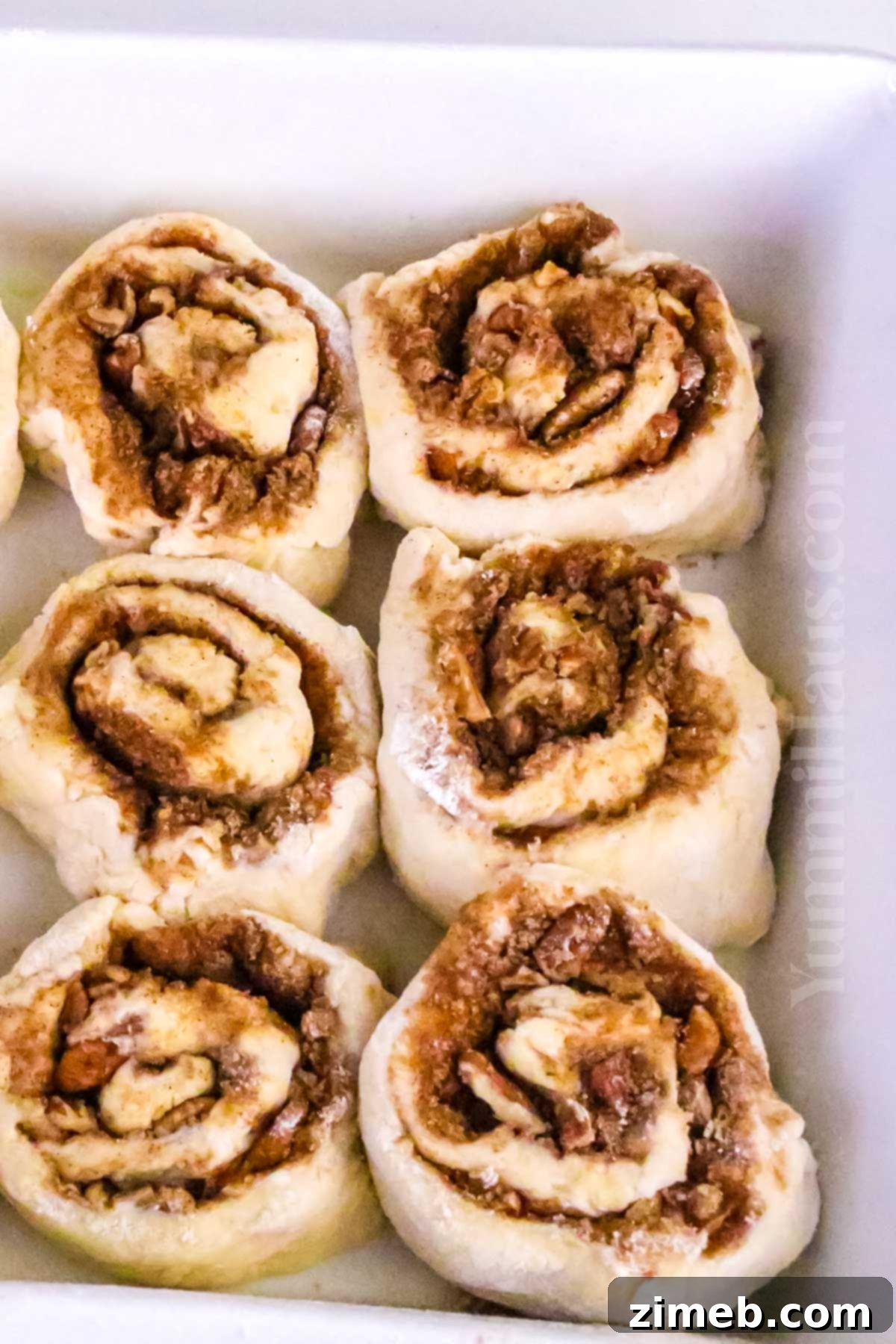 Spiced Banana Swirl Buns 7 Banana Bread Cinnamon Rolls ready to bake in a dish.
