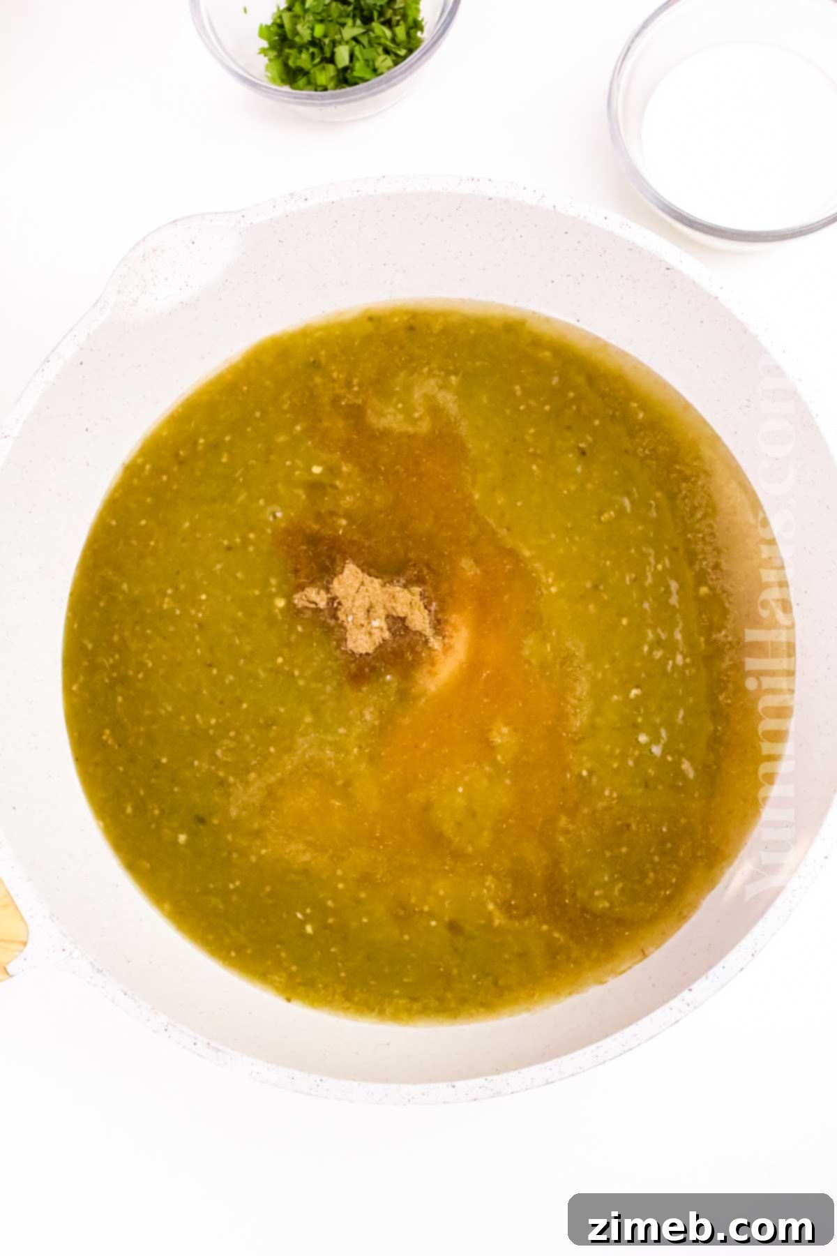 Homemade tangy green salsa for Chilaquiles Verdes, made from tomatillos, green chilies, garlic, and onions.