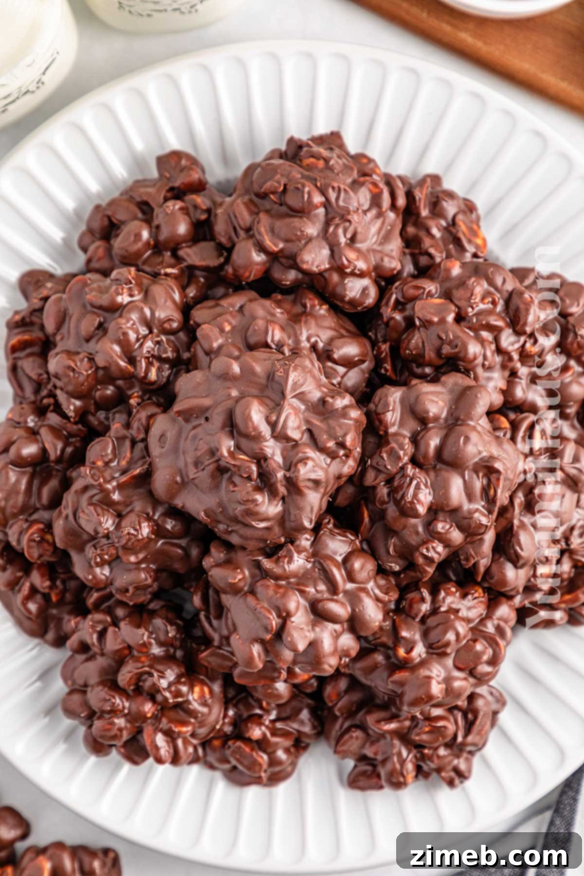 Close-up of slow cooker peanut clusters with sprinkles, showing rich chocolate and nuts.