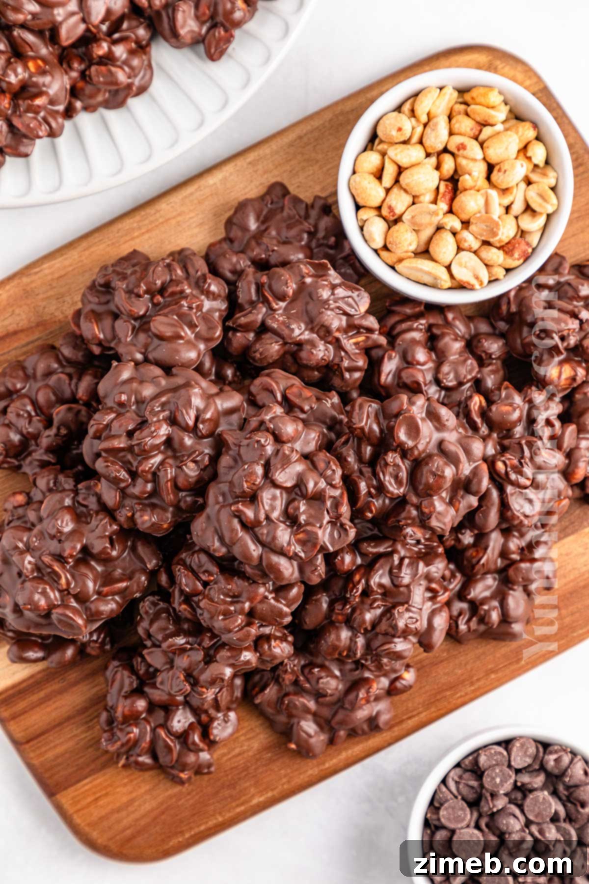 A large batch of finished Crockpot Candy clusters with sprinkles on a platter.