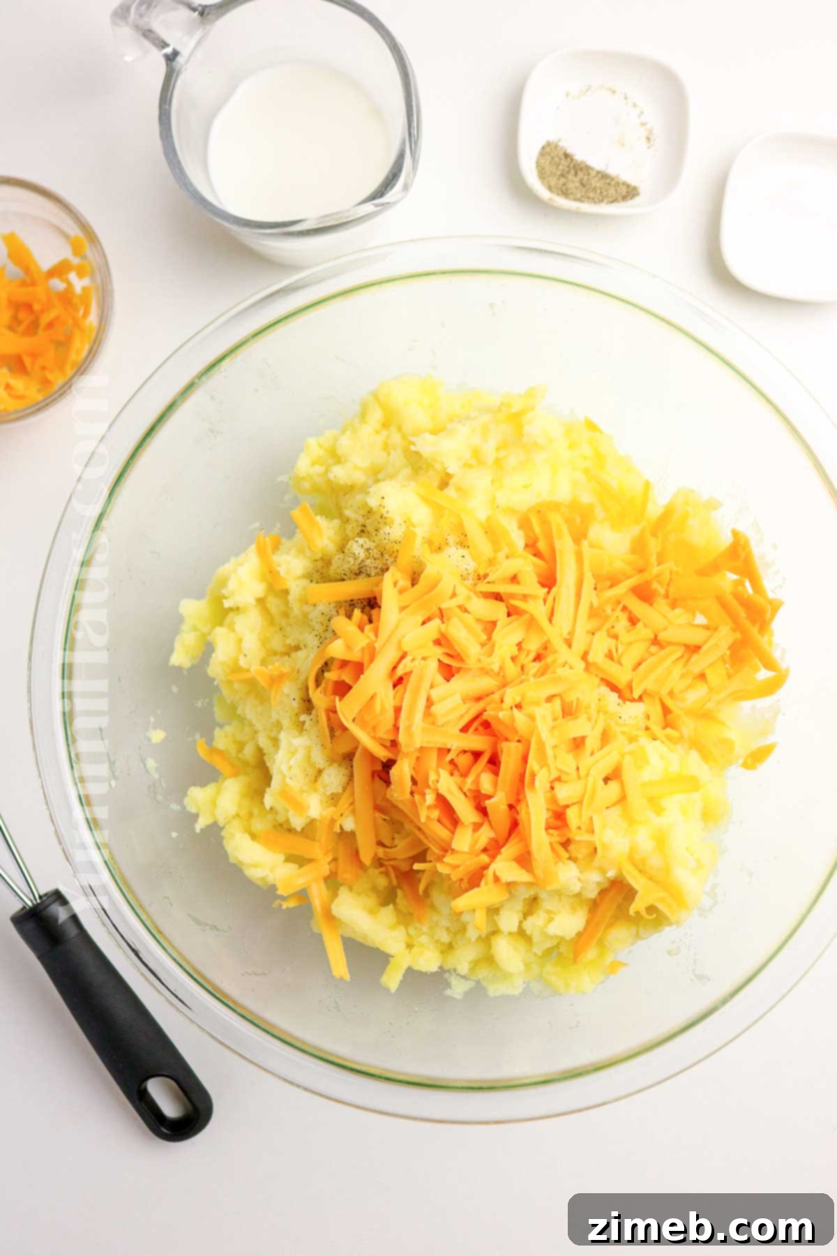 Adding shredded cheddar cheese to mashed potatoes