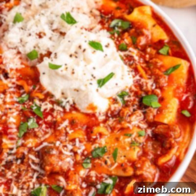 Tuscan Sausage, Kale, and White Bean Soup 9 A bowl of Slow Cooker Lasagna Soup with melted cheese and fresh basil garnish.