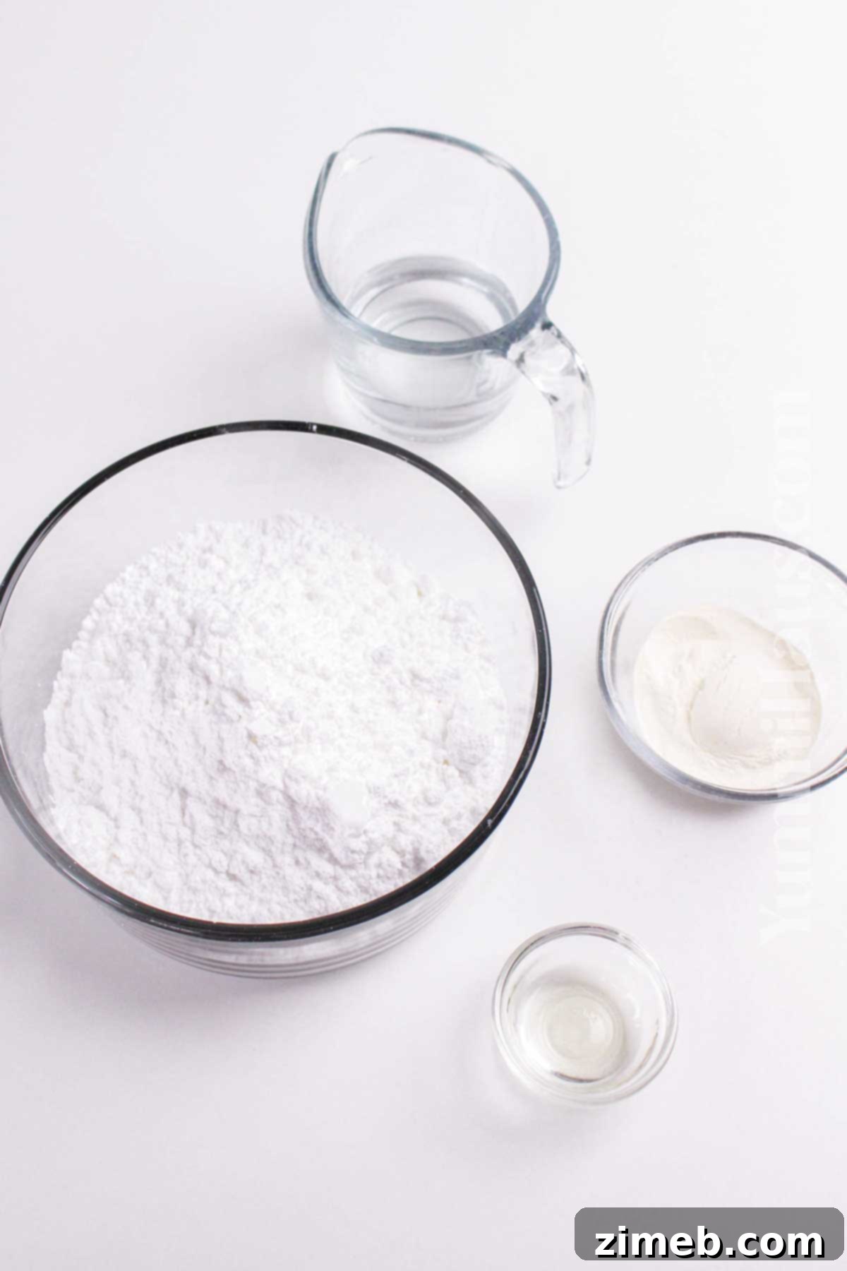 The essential ingredients for royal icing: confectioner's sugar, meringue powder, water, and vanilla extract.