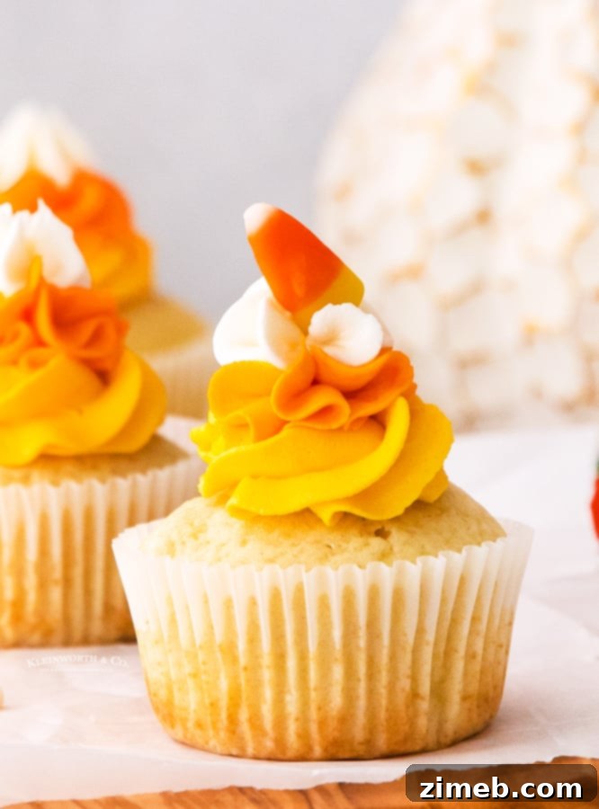 Festive Candy Corn Cupcakes topped with yellow, orange, and white vanilla buttercream frosting, perfect for Halloween and Thanksgiving parties.
