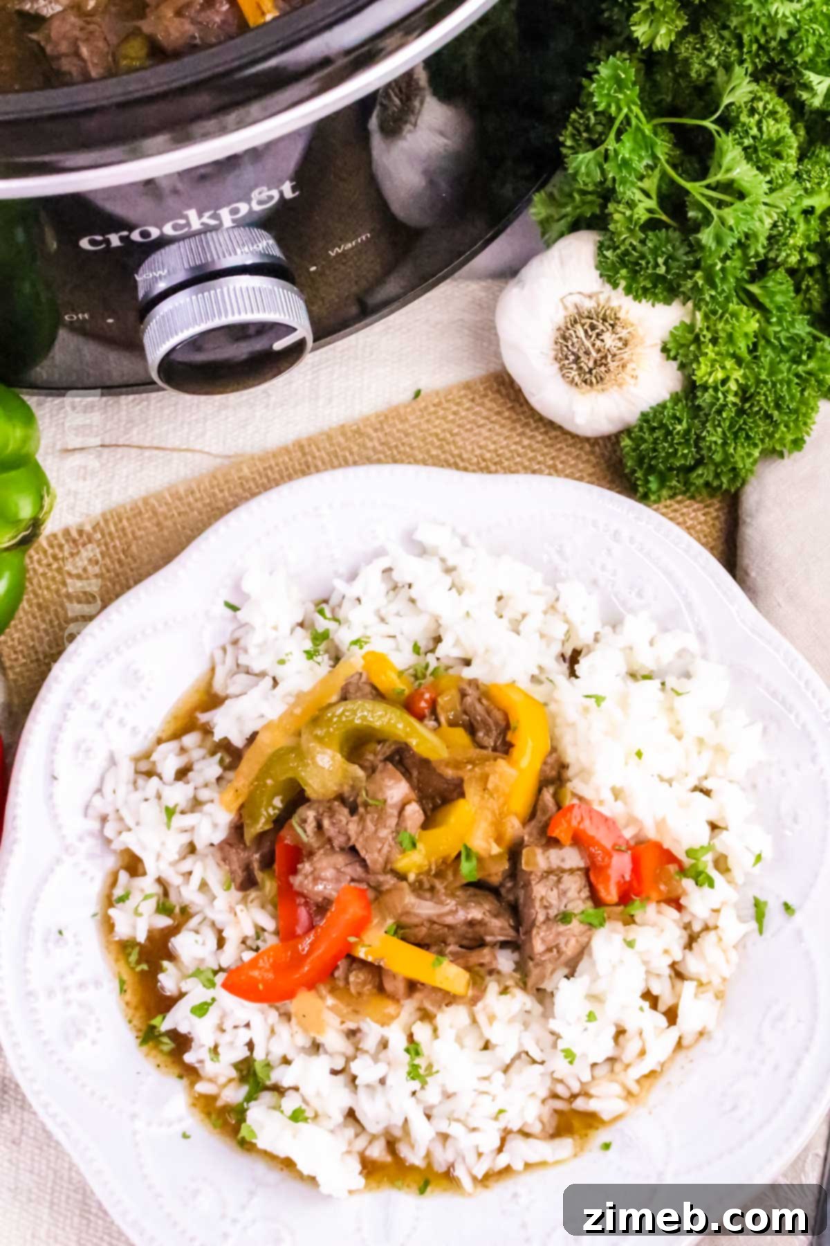 Tender Slow Cooker Pepper Steak 3 Close-up of Slow Cooker Pepper Steak, showing tender beef and colorful vegetables swimming in sauce.