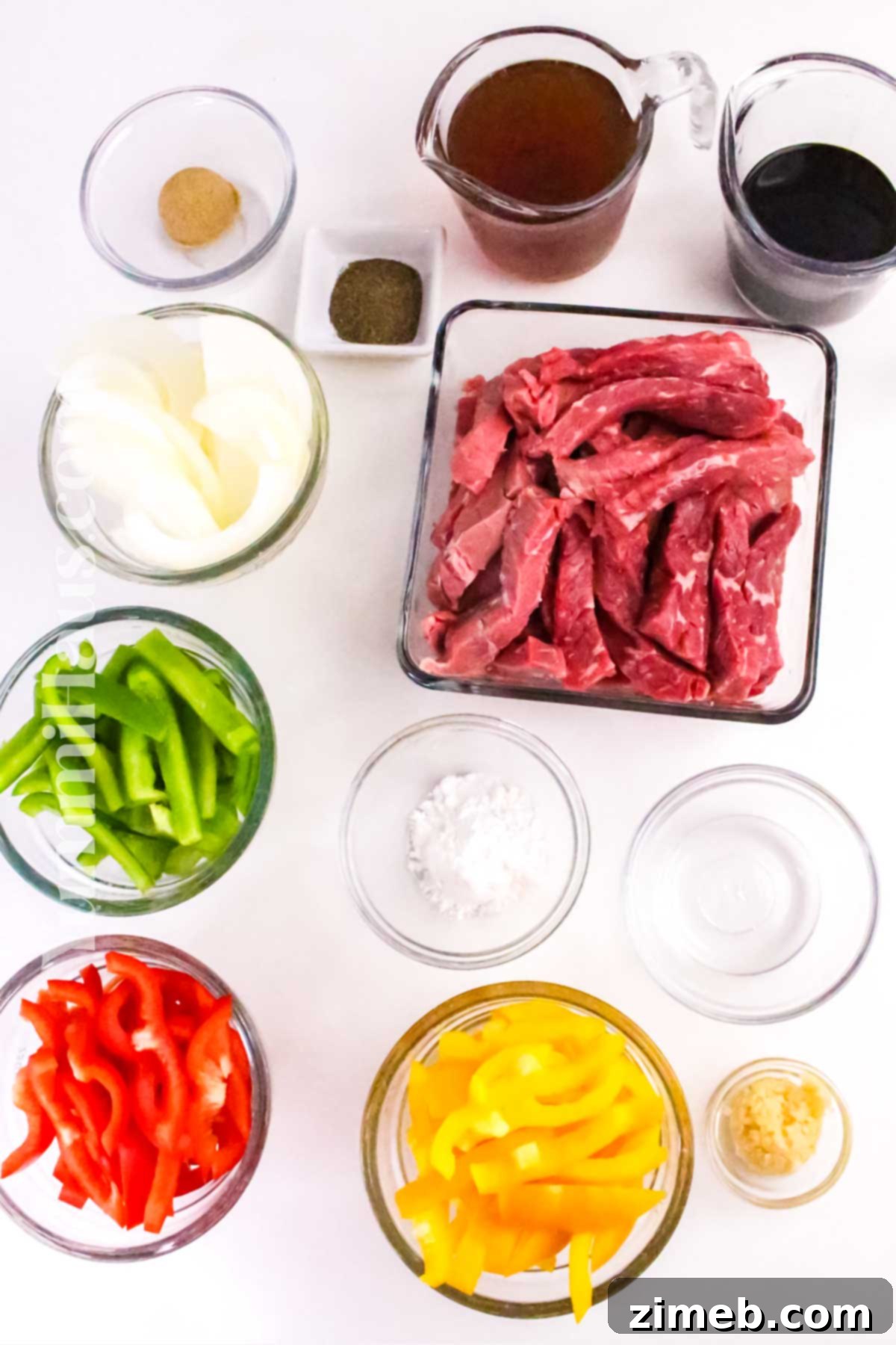 Tender Slow Cooker Pepper Steak 4 Fresh ingredients laid out for Slow Cooker Pepper Steak, including colorful bell peppers, sliced beef, and onions.