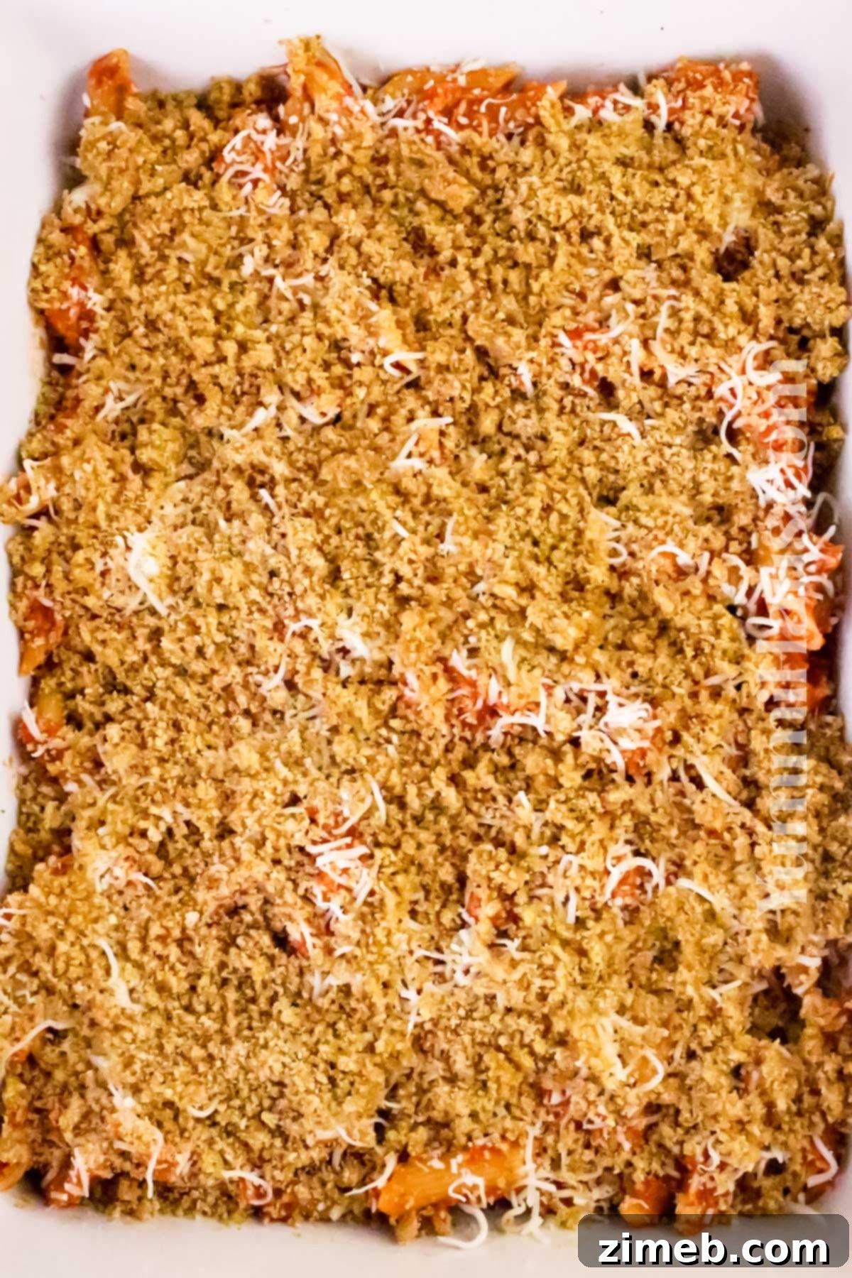 Adding the buttery crumb topping to Chicken Parmesan Casserole.