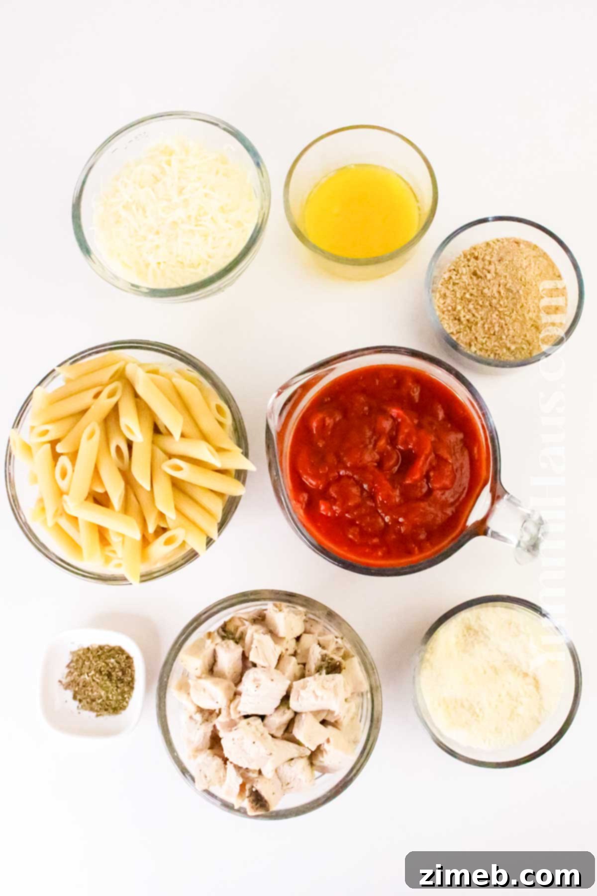 Ingredients for Chicken Parmesan Casserole arranged on a cutting board.