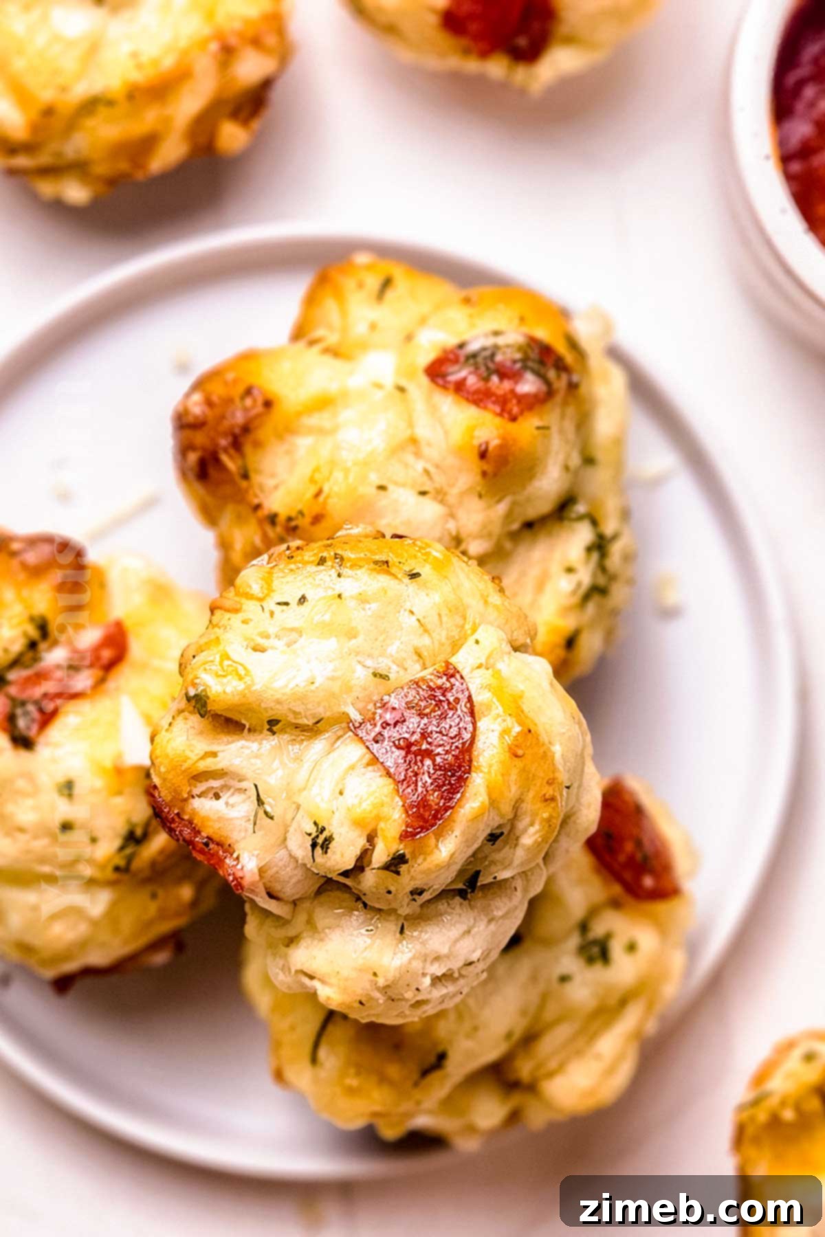 Close-up of baked Pizza Muffins, showing golden crust and melted cheese inside, perfect for a savory snack.