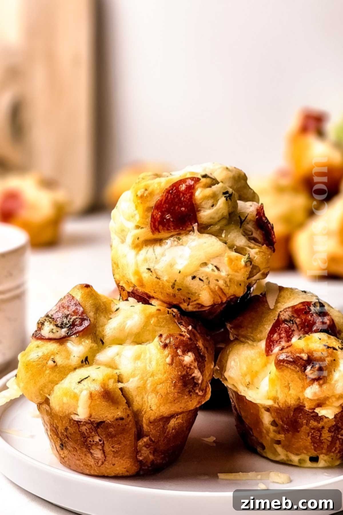 Brushing garlic butter on warm savory muffins after baking, enhancing flavor and moisture.