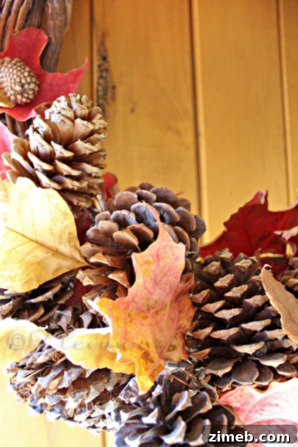 Close-up of a handmade fall wreath, showcasing beautifully integrated leaves and sturdy pine cones.