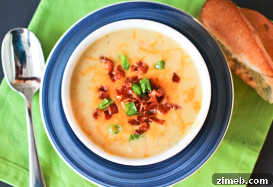 A close-up of a bowl of Idaho Potato Soup, showing its creamy texture and rich toppings.