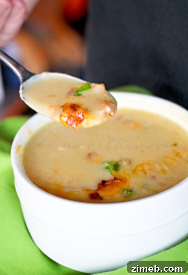 Idaho Potato Soup in a rustic bowl, garnished with green onions and bacon bits.