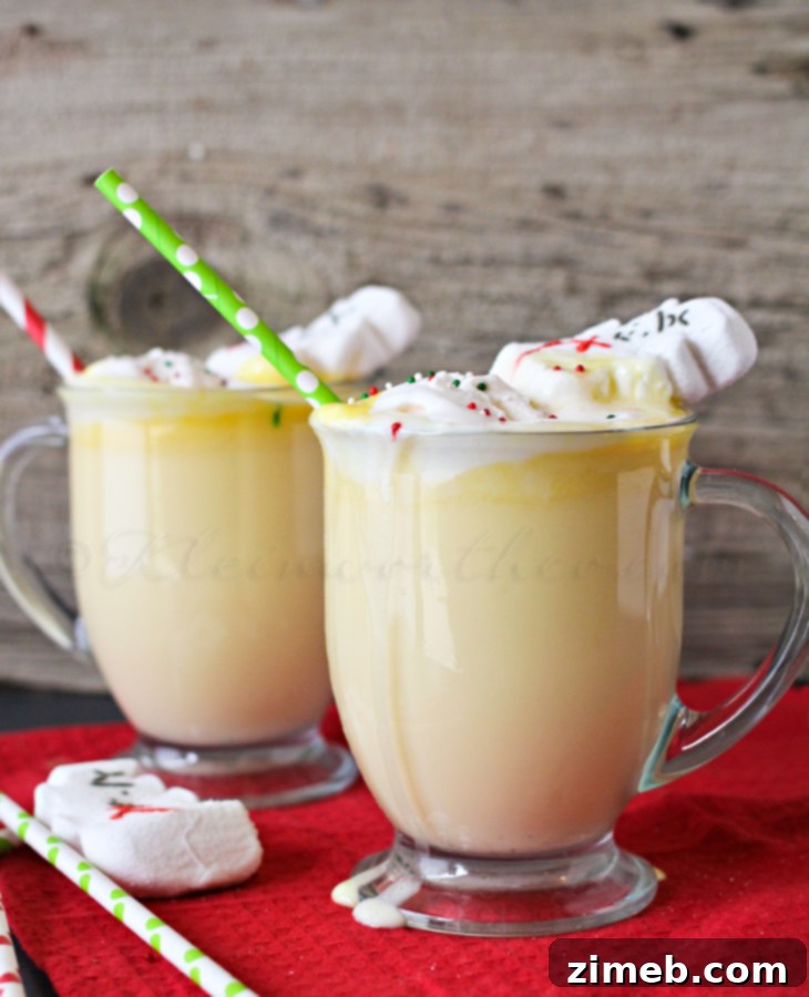 Eggnog Hot Chocolate in a mug with whipped cream and a holiday straw, ready to be enjoyed