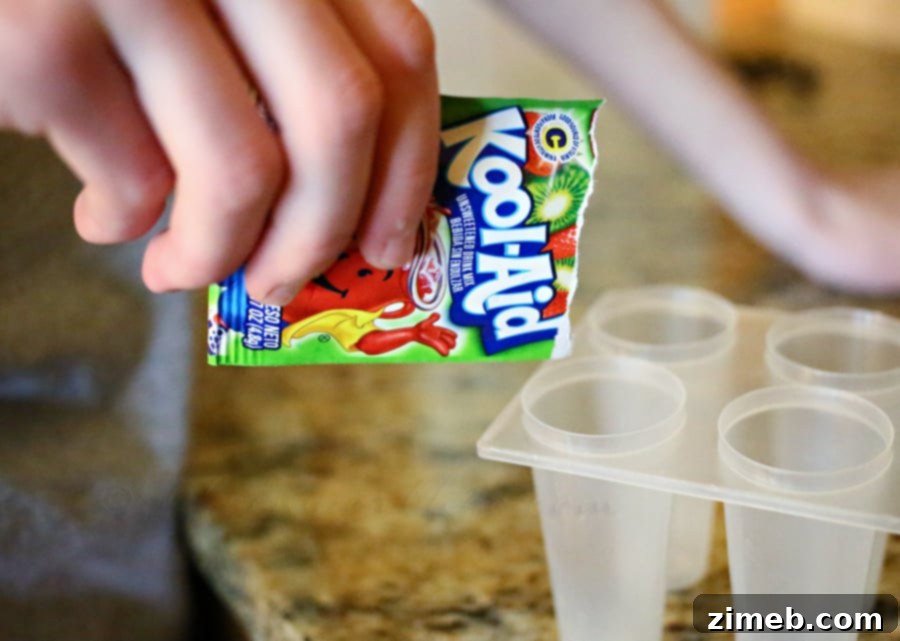Quick & Cool Ice Pops 3 Kool-Aid Strawberry Kiwi powder packet, ready to be used for homemade popsicles.