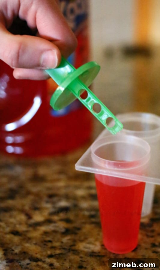 Quick & Cool Ice Pops 5 Filling popsicle molds with ready-to-drink Tropical Punch Kool-Aid.