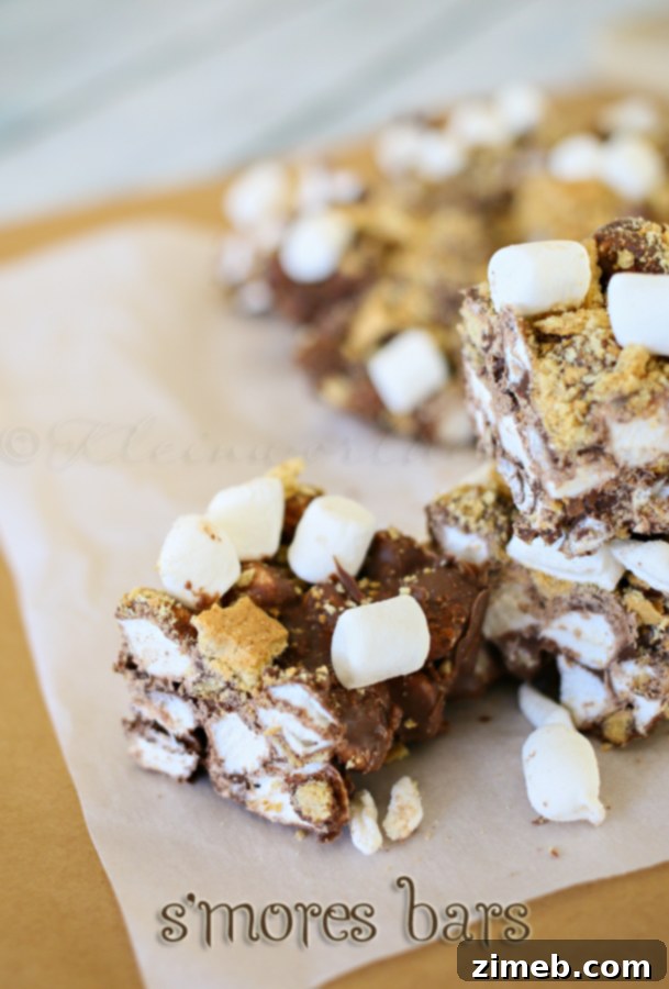 No-bake s'mores bars neatly cut into perfect squares within a parchment-lined baking dish, ready for serving