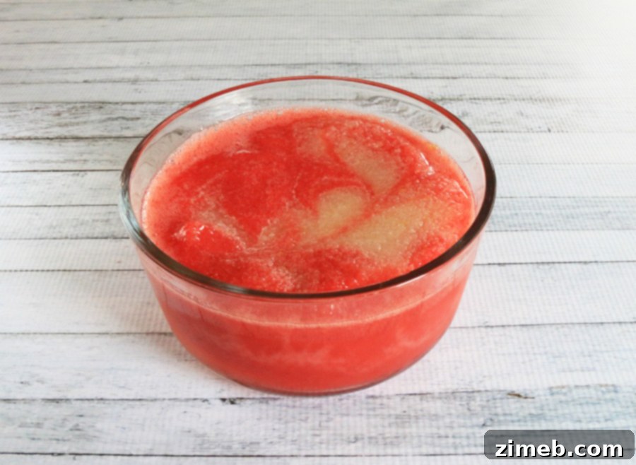 Zesty Berry Bliss Sorbet 3 Scoops of refreshing strawberry lemon sorbet with a perfect swirl, served in a clear glass, an ideal no-churn dessert.