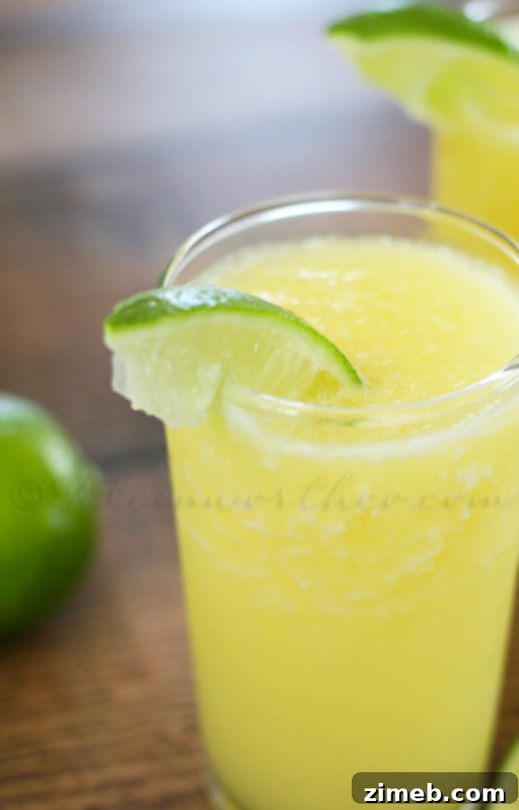 Refreshing Pineapple Sparkler served in a tall glass with lime and pineapple garnish, set against a bright, summery background.