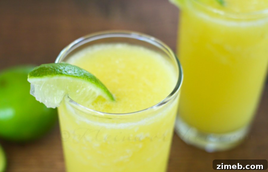 A vibrant display of fresh pineapple chunks, whole limes, a jar of coconut cream, and a can of sparkling water, ready for blending a Pineapple Sparkler.