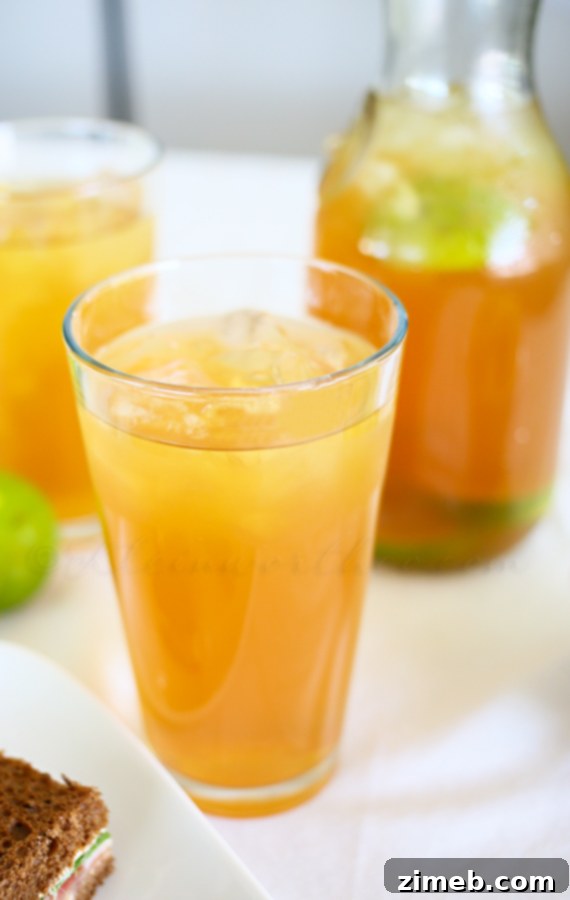 Tropical Coconut Lime Tea 3 Refreshing Coconut Lime Tea served in a tall glass with ice and a lime wedge, a perfect homemade beverage.
