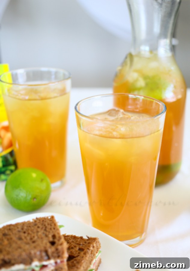 Tropical Coconut Lime Tea 4 Close-up of Coconut Lime Tea in a glass pitcher, showing the beautiful amber color and fresh lime slices.