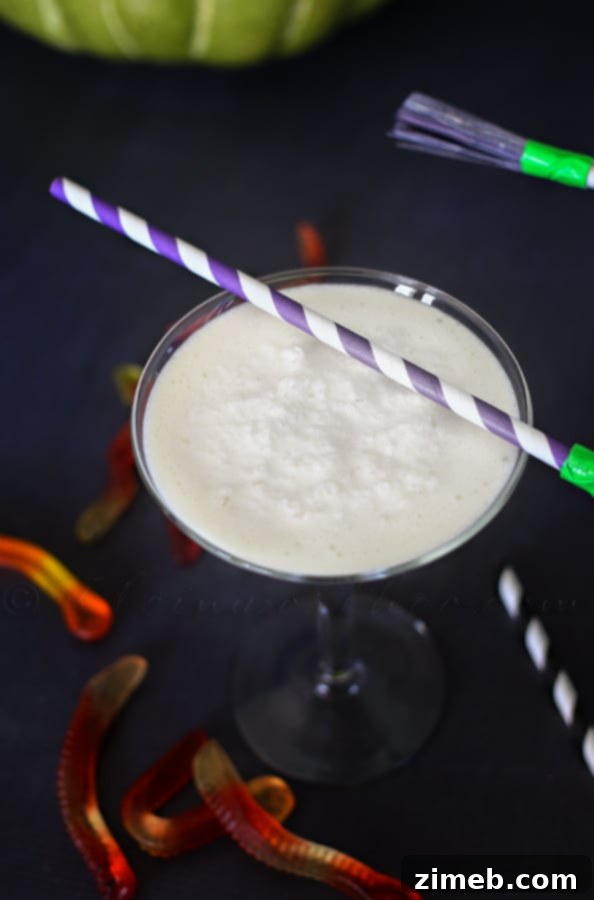 Close-up of a White Witch Cocktail in a goblet, garnished for Halloween
