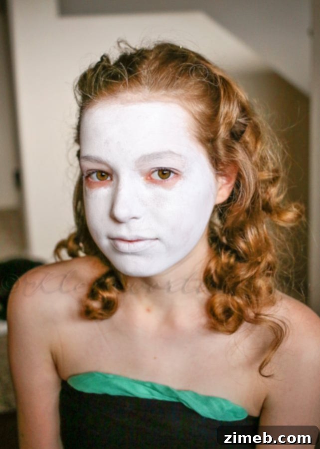 Applying white base face paint for sugar skull look