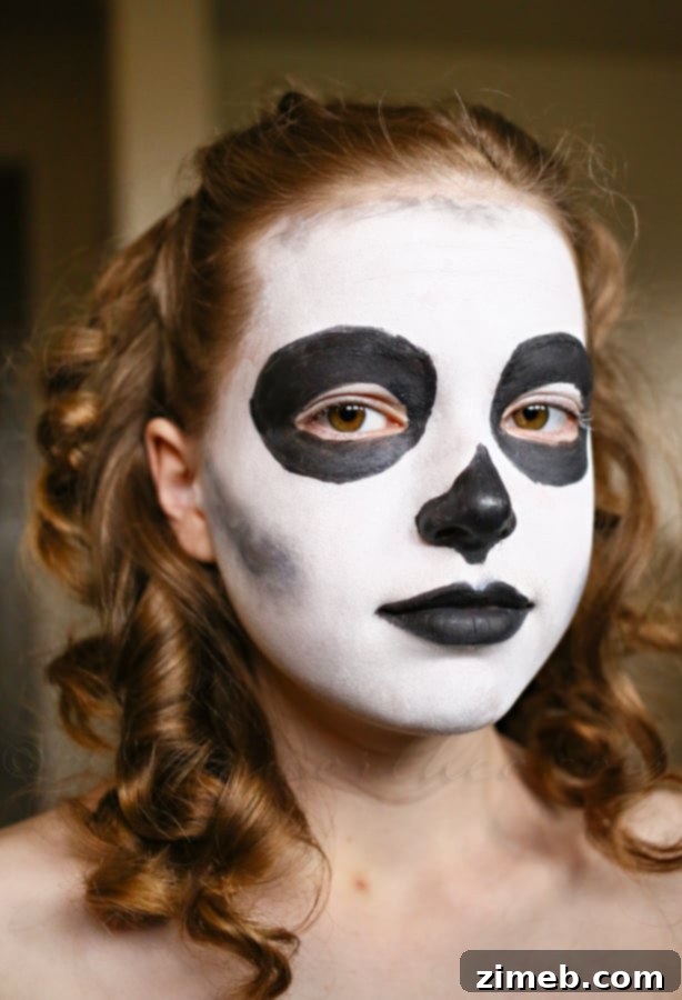 Adding black details for eyes, nose, and cheekbones in sugar skull makeup
