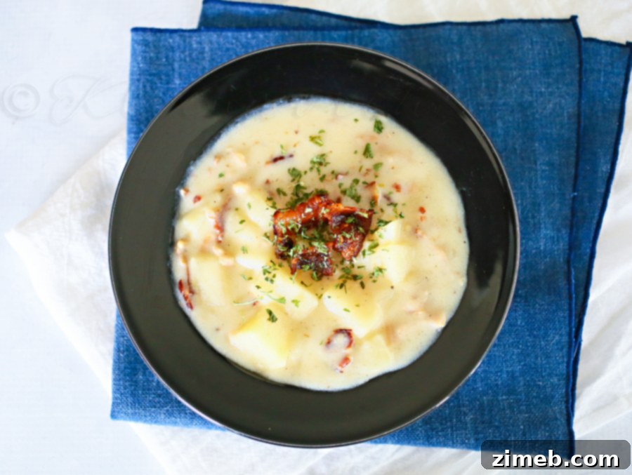 Slow Cooker Clam Chowder Hearty bowl of Slow Cooker Clam Chowder with crusty bread