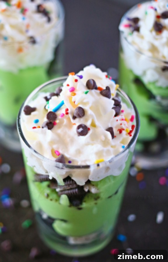 Pot o' Gold Dessert Shooters 3 Close-up of a Leprechaun Dessert Shooter with green pudding, crushed Oreos, whipped cream, and rainbow sprinkles.