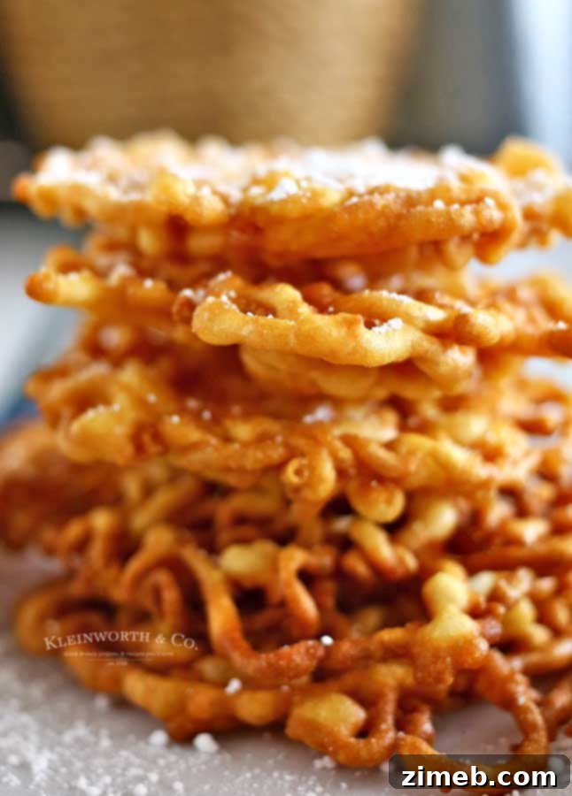 A freshly fried Funnel Cake, golden brown and ready for powdered sugar, a perfect fair treat.