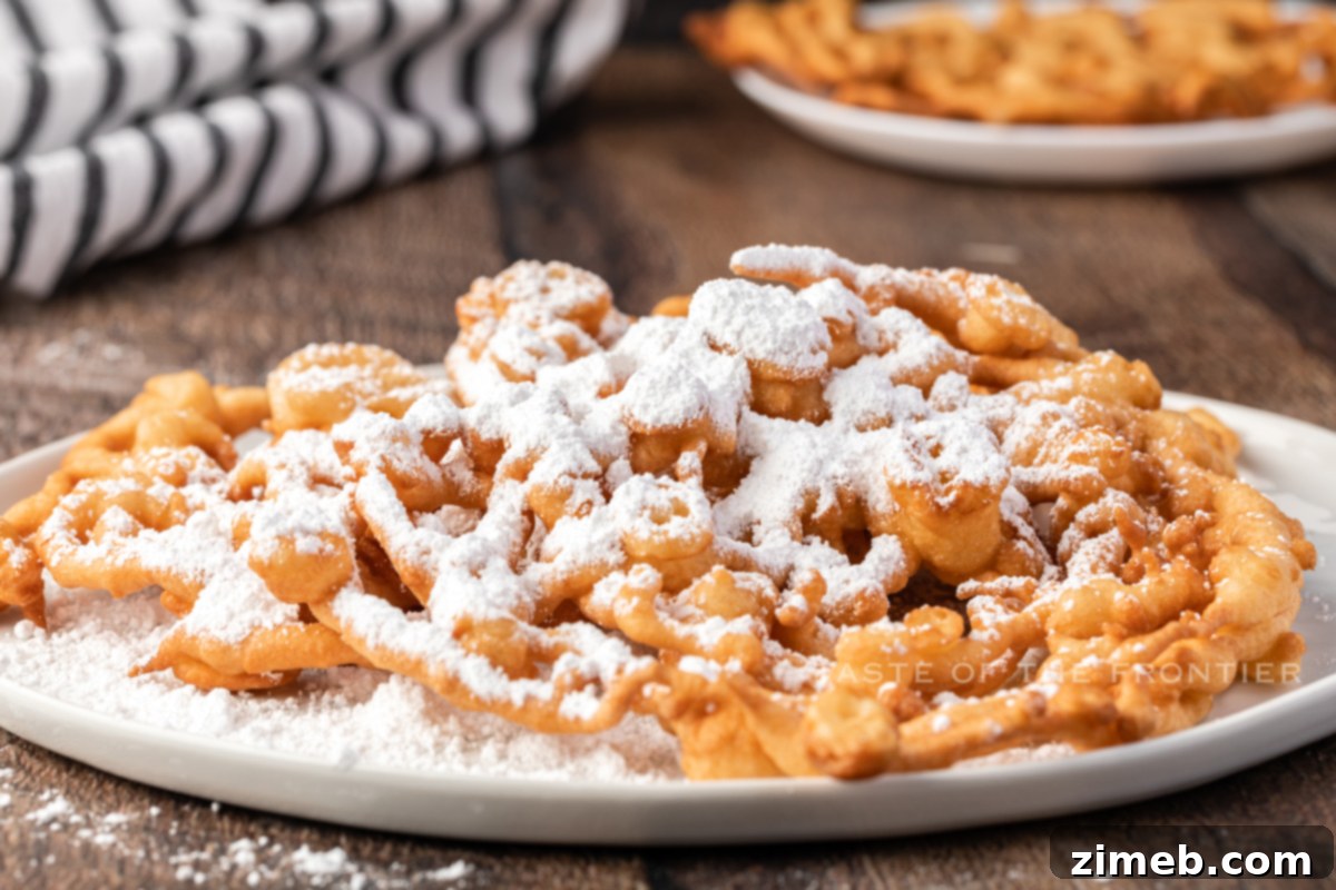 Freshly made homemade Funnel Cake being removed from hot oil, golden and crispy.