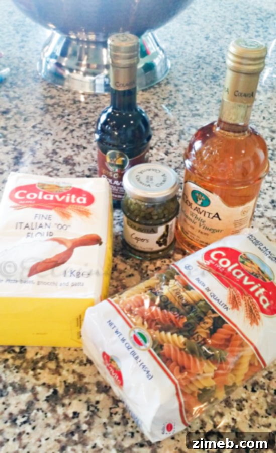 A curated selection of Colavita ingredients for Italian cooking: extra virgin olive oil, tri-color fussilli pasta, white balsamic vinegar, and fine Italian flour.