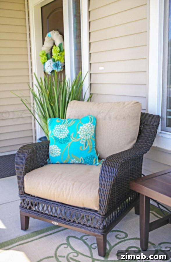 Summer Porch Makeover - Elegant wicker furniture with blue and green pillows, a long coffee table, and a welcoming ambiance.