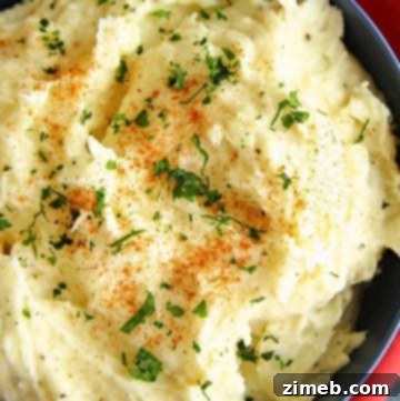 Blue Cheese Sunrise Stack 13 A bowl of creamy garlic mashed potatoes, topped with melted butter and garnished with fresh herbs. The smooth, fluffy texture of the potatoes is highlighted by the rich, buttery sheen, making the dish look warm, comforting, and flavorful. Perfect as a savory side dish for any meal.
